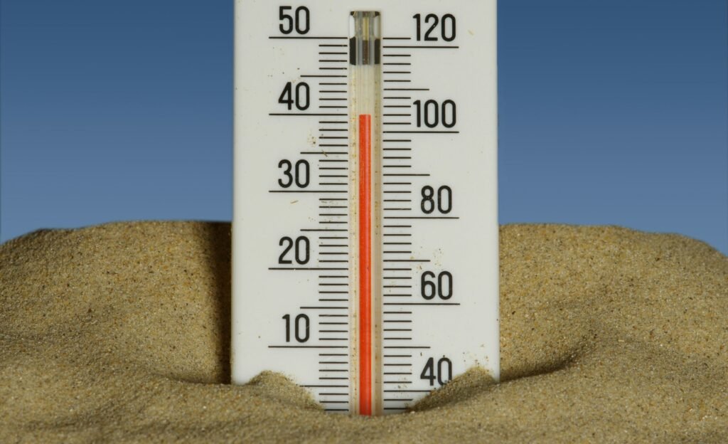 Thermometer in the sand showing heatwave temperatures