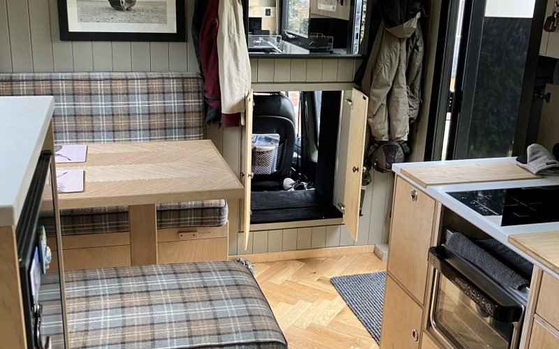 Leyland DAF T244 expedition truck interior: wide view of seating area, crawl-through, habitation door and partial kitchen