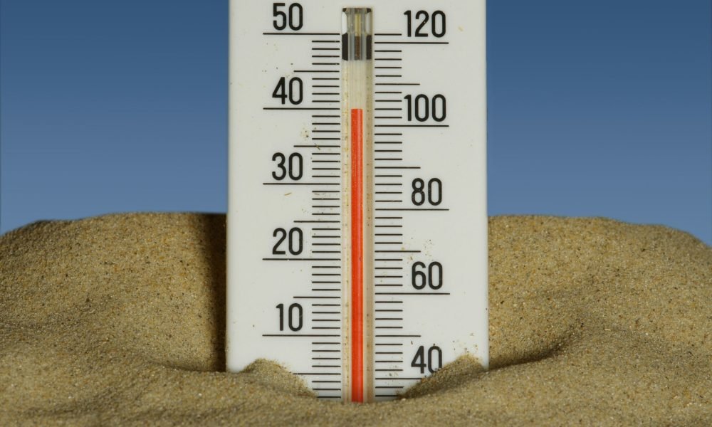 Thermometer in the sand showing heatwave temperatures